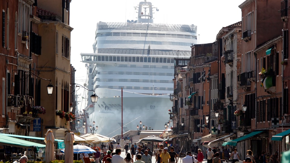 Kreuzfahrtschiff vor Venedig, fotografiert durch eine Gasse.