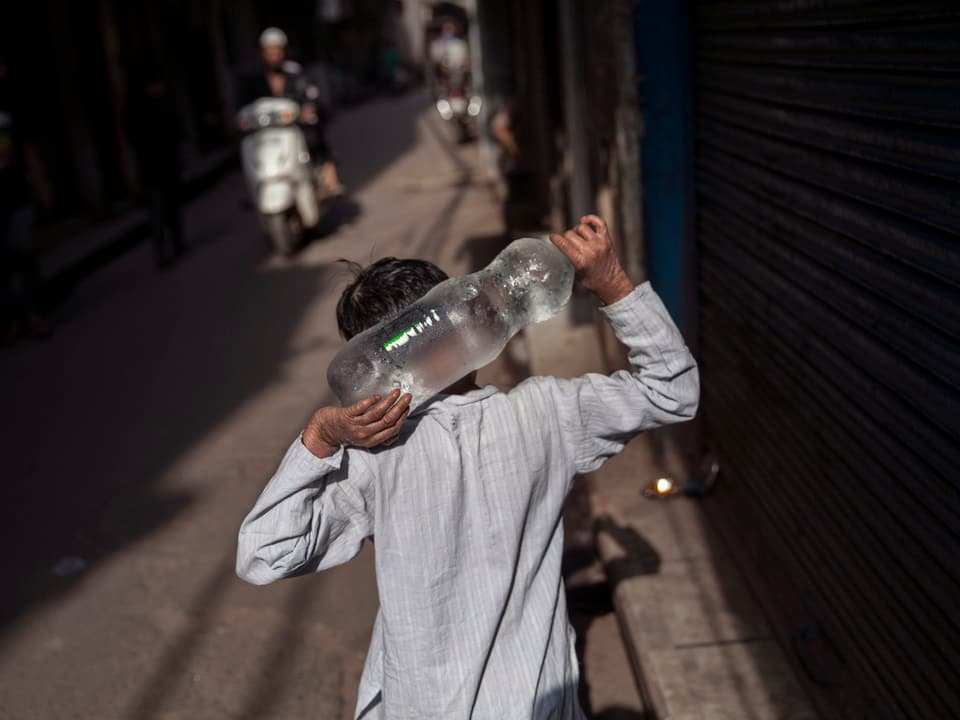 Rückenansicht eines Jungen, der eine Wasserflasche trägt