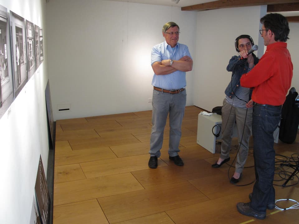 Paul Rutz, Radka Laubacher mit Mikrofon und Bruno Meier stehen im Museum.