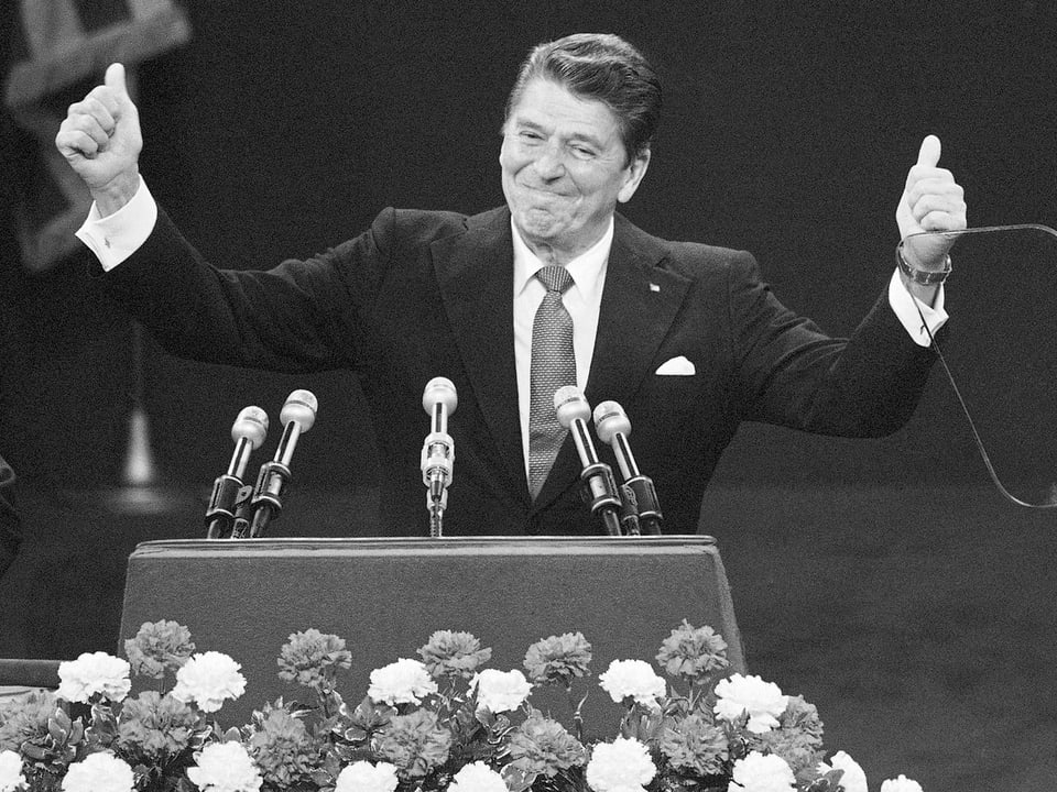 Reagan am Rednerpult - bei Daumen hebend.