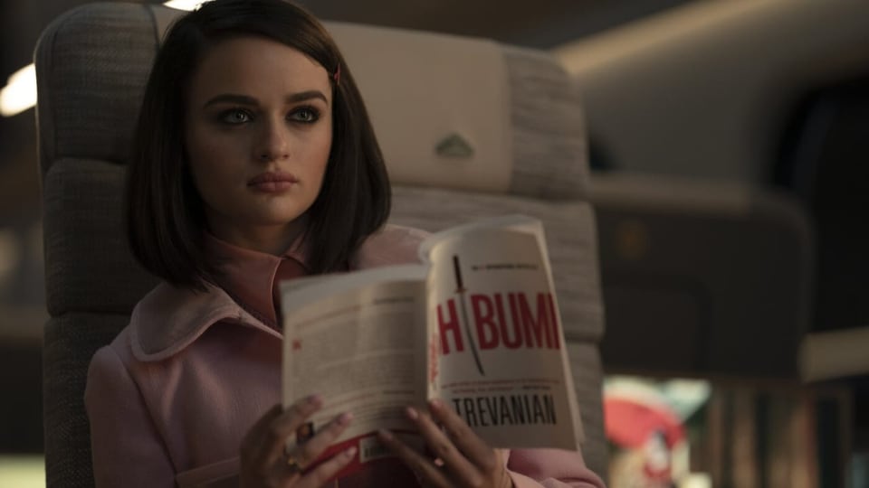 A young girl is holding a book