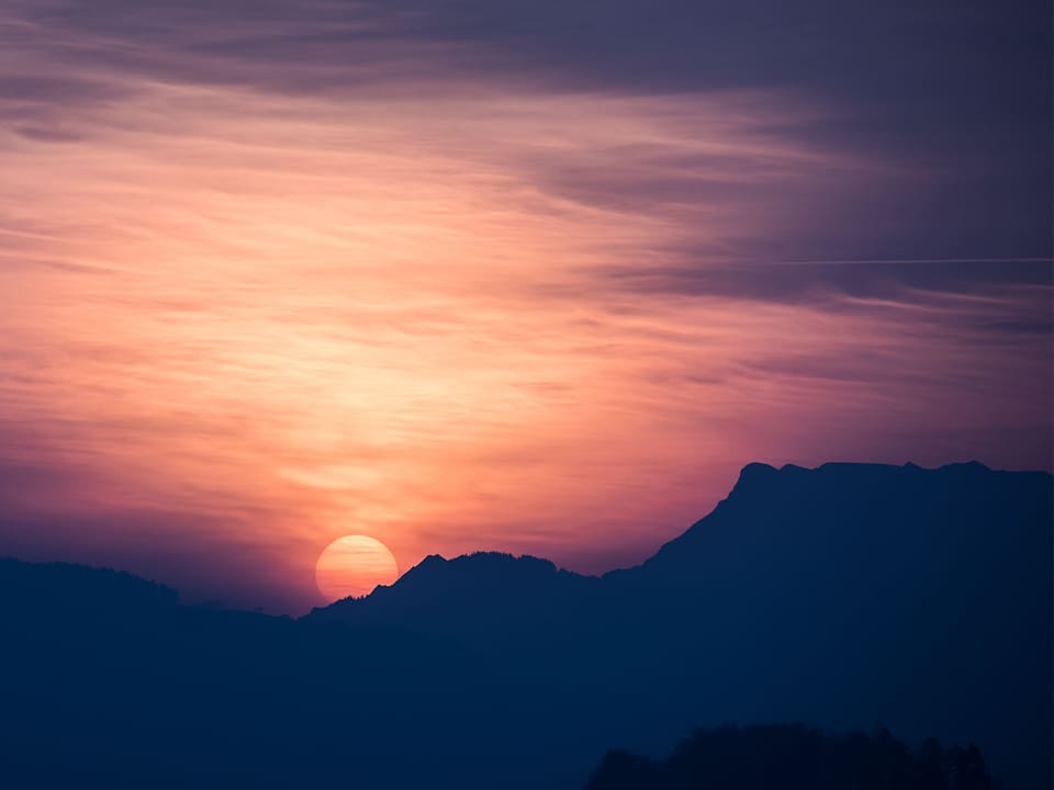 Ein zarter Wolkenschleier begleitet den Sonnenaufgang über dem Titlis.