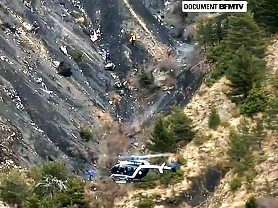 Ein Helikopter fliegt über den Unfallort in den Alpen in Südfrankreich.
