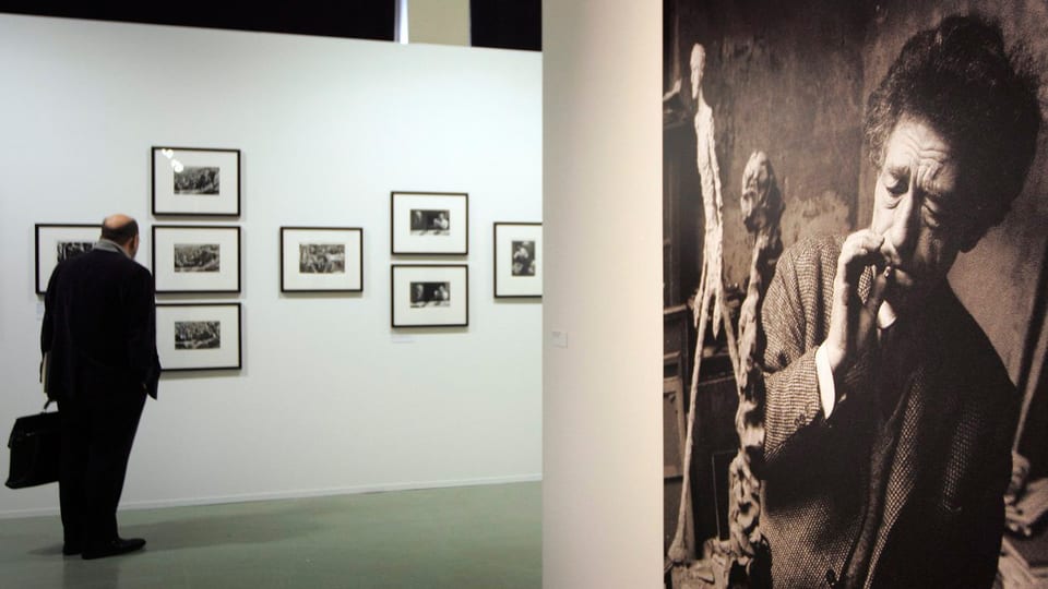 Ein Foto von Giacometti hängt in einem Ausstellungsraum.