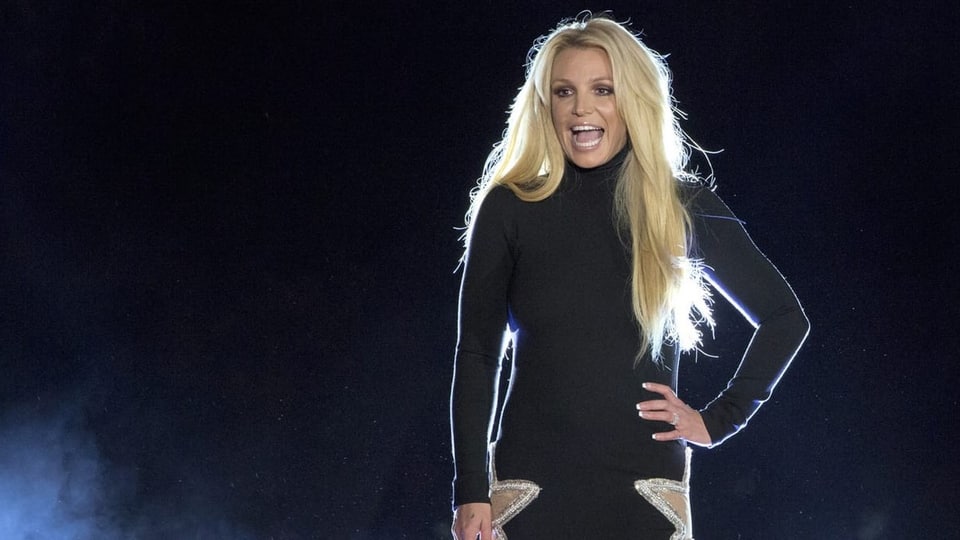 Britney Spears steht auf einer Bühne und lacht