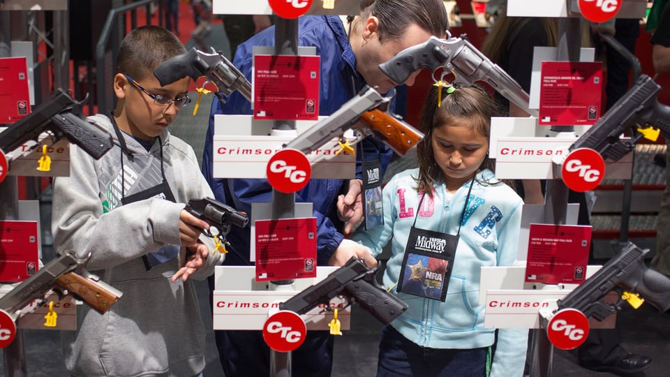 Kinder mit Eltern in einem Waffengeschäft in den USA.