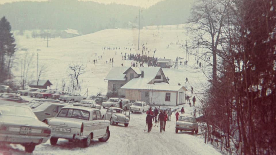 Altes Foto: Voller Parkplatz vor einem Skilifthäuschen