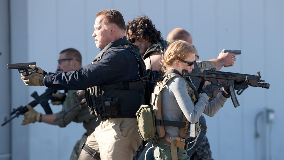 Ein bewaffnete Gruppe von Menschen Rücken an Rücken.