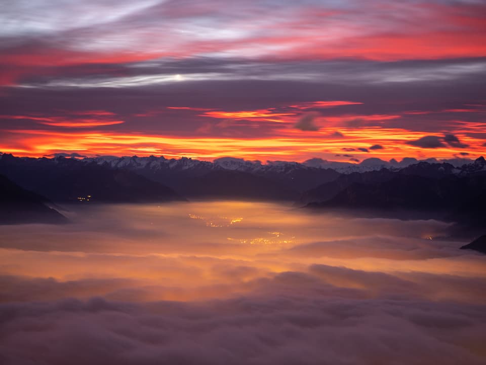 Rote Morgenstimmung: Unten Nebel, oben Wolkenfelder, im Hintergrund der rotgefärbte Horizont. 