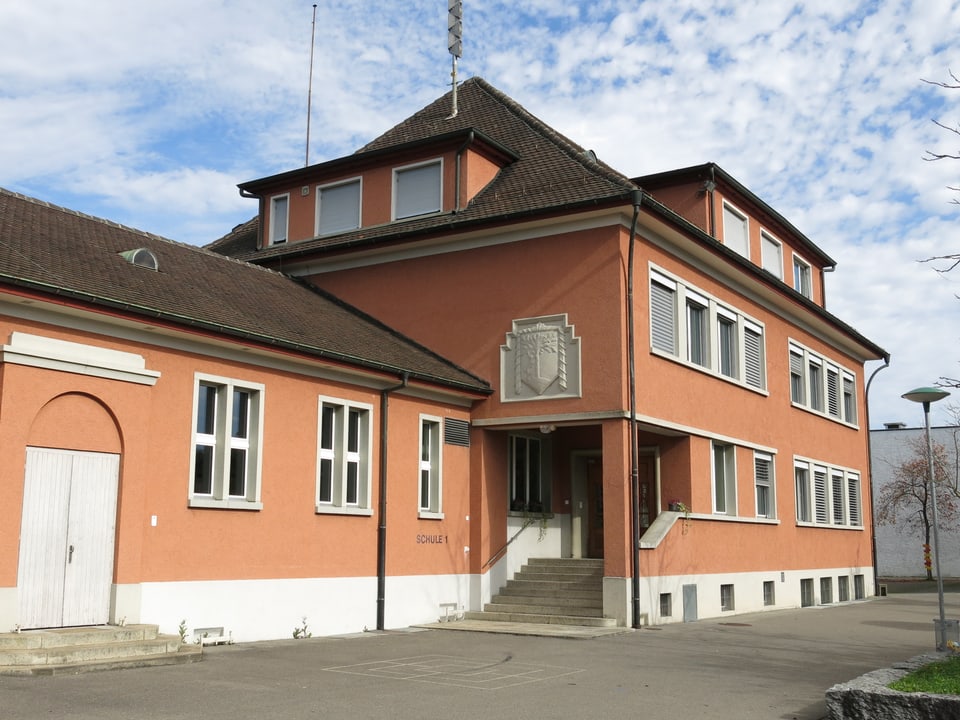 Schulhaus Rotkreut - orange-rotes Gebäude.