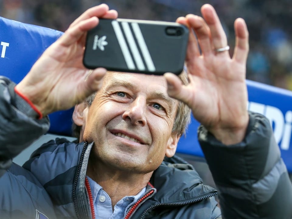 Jürgen Klinsmann knipst ein Foto. 