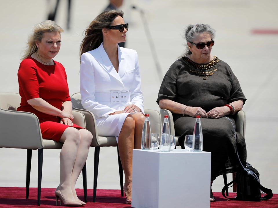 Die drei Damen warten auf die Reden ihrer Männer.