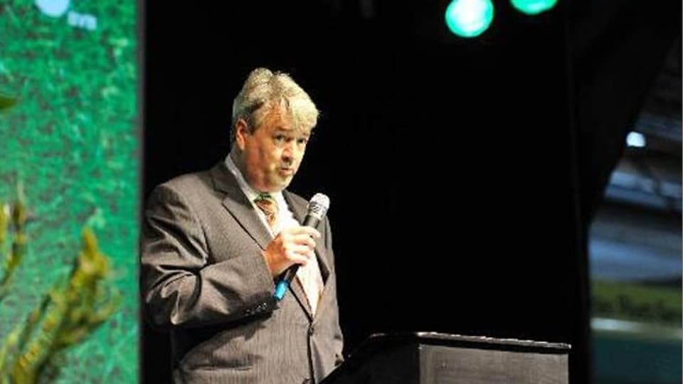 Martin Gudenrath spricht zum Publikum. Steht auf der Bühne mit Mikrofon in der Hand. 