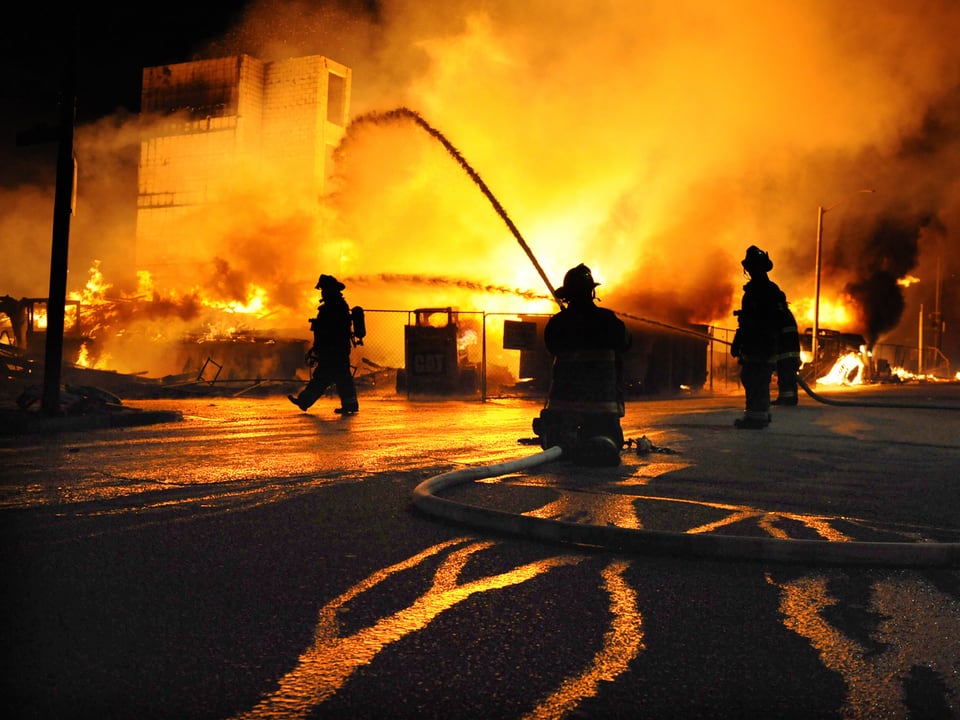 Die Feuerwehr beim Löschen eines brennenden Gebäudes. 