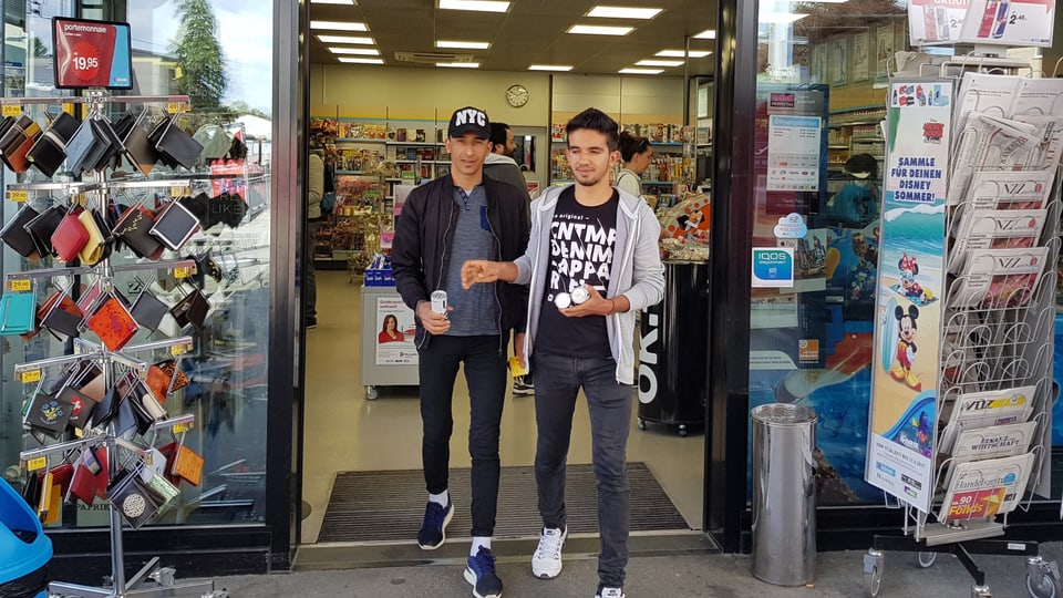 zwei junge Männer verlassen einen Kiosk