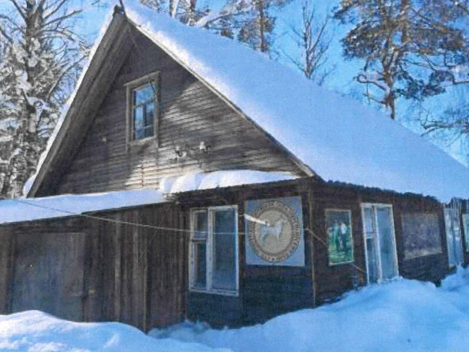Eine Jagdhütte im verschneiten Wald.