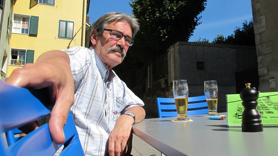 Zanetti sitzt vor einer Stange Bier an einem Tisch des Restaurants.