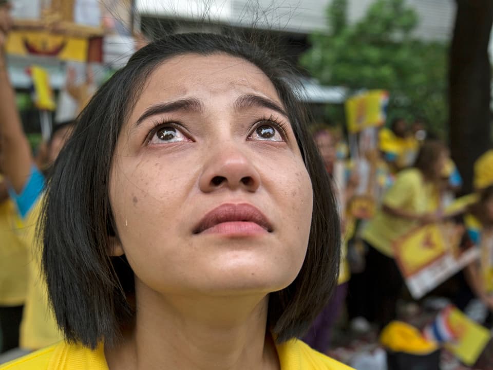 Eine junge Frau steht vor dem Spital in Bangkok, mit Tränen in den Augen, und sorgt sich um ihren König (2005). (getty images)