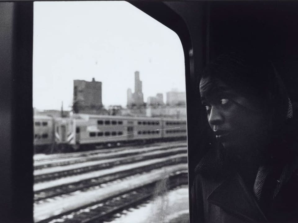 Frau schaut aus einem Zug.