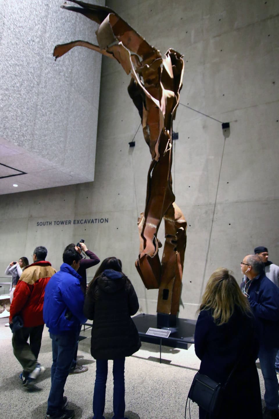 Touristen fotografieren einen geschmolzenen Stahlträger an der Gedenkstätte Ground Zero Memorial 