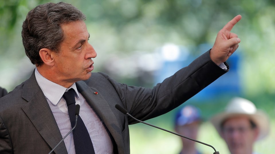 Nicola Sarkozy mit erhobenem Zeigefinger während einer Ansprache.