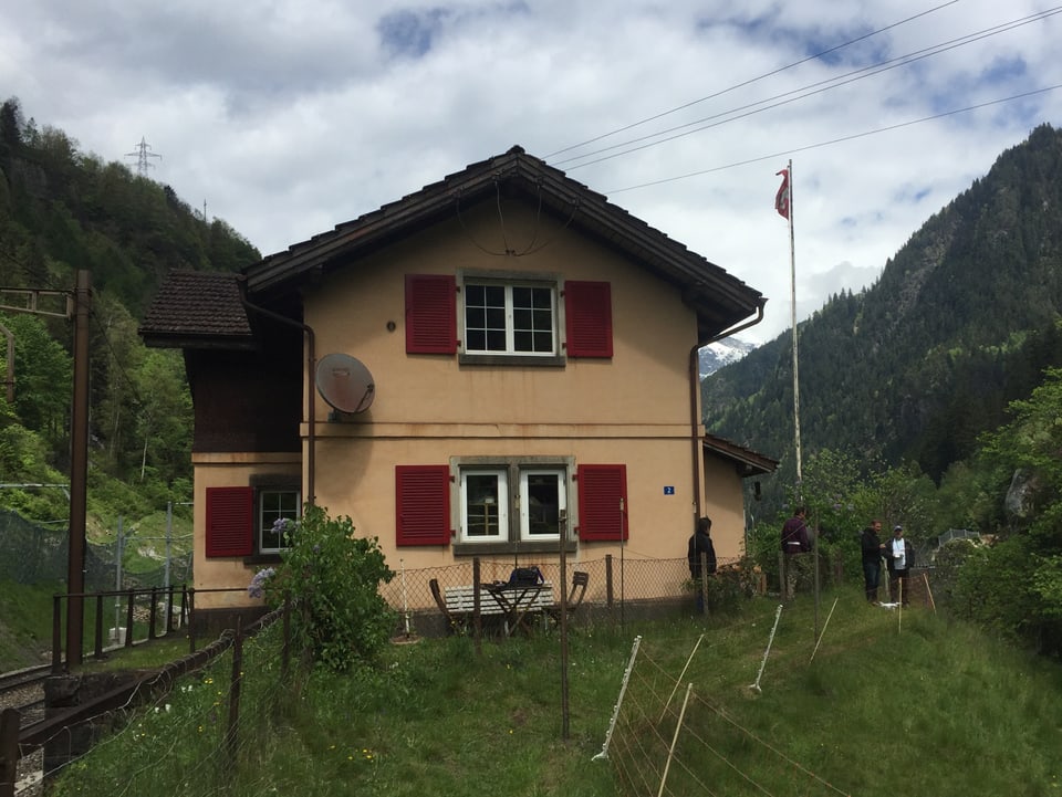 kleines gelbes Haus direkt an einer Bahnlinie im Berggebiet