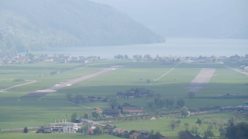 Blick auf den Flugplatz Buochs NW aus der Luft. Die Aufnahme zeigt einen grossen Flugplatz direkt am See.