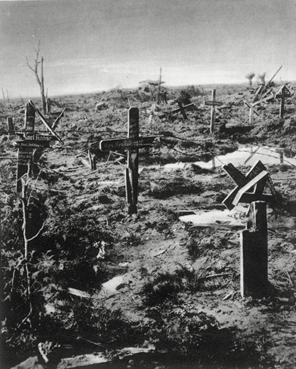 Feld mit zerstörten Grabkreuzen aus Holz.