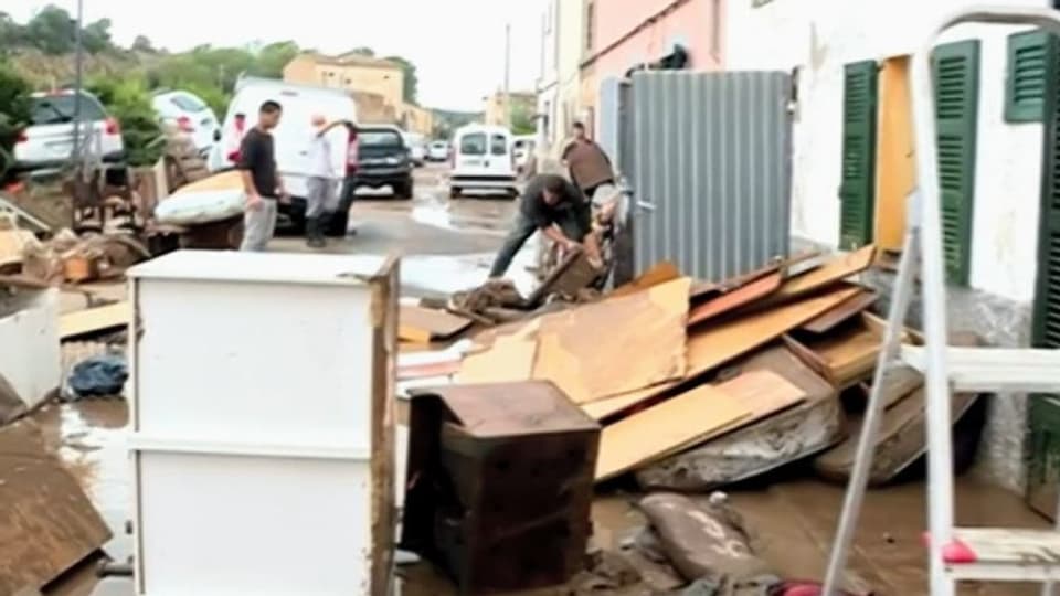 Bewohner eines Hauses stellen zerstörte Möbel auf die Strasse.