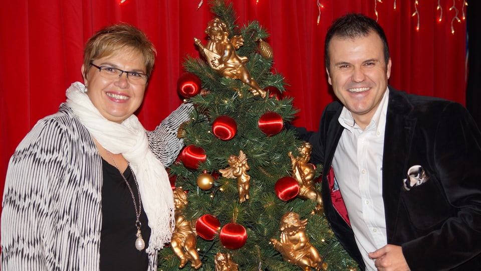 Christine Gertschen und Joël Gilgen neben geschmücktem Weihnachtsbaum.