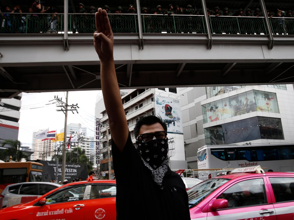 Maskierter Mann in Bangkok protestiert mit der «Hunger Games»-Geste.