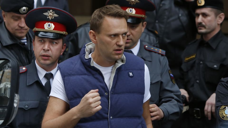 Nawalny wird von Polizisten abgeführt.