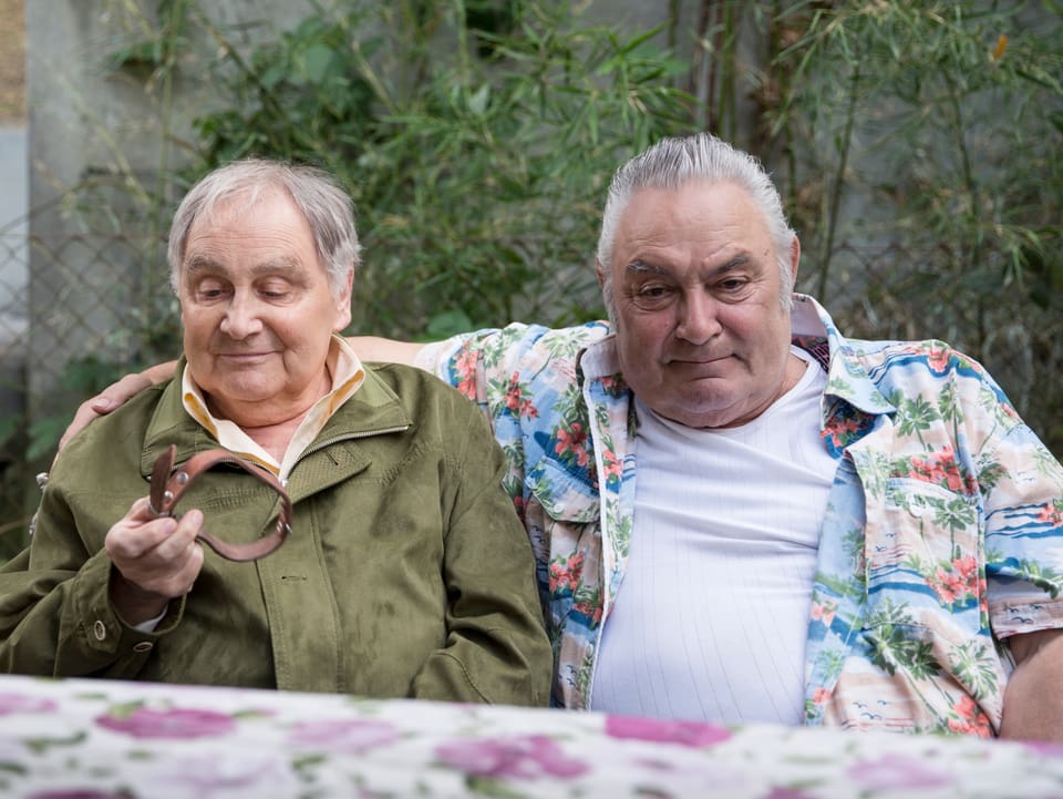 Zwei ältere Männer sitzen an einem Tisch