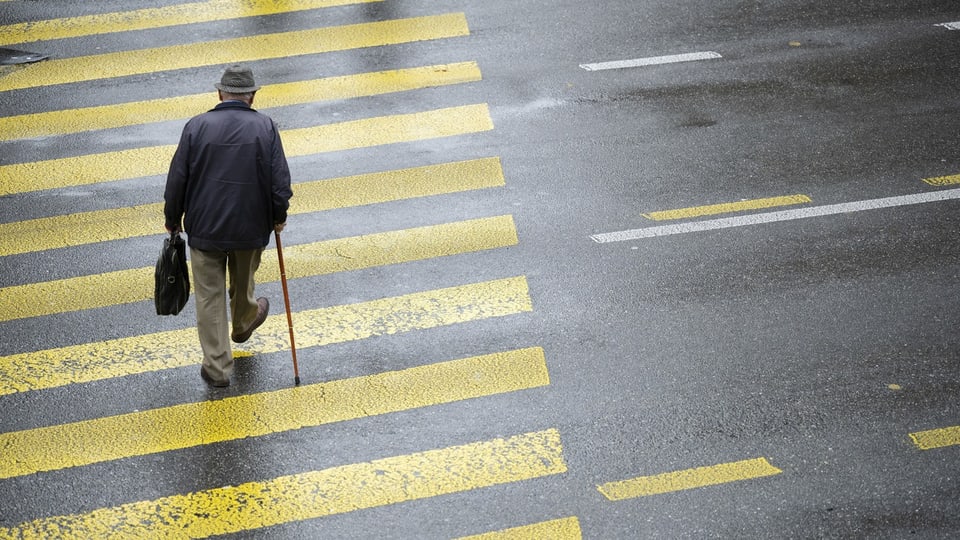 Ein älterer Taxifahrer schliesst die Tür seines Taxis am Bahnhof Luzern.
