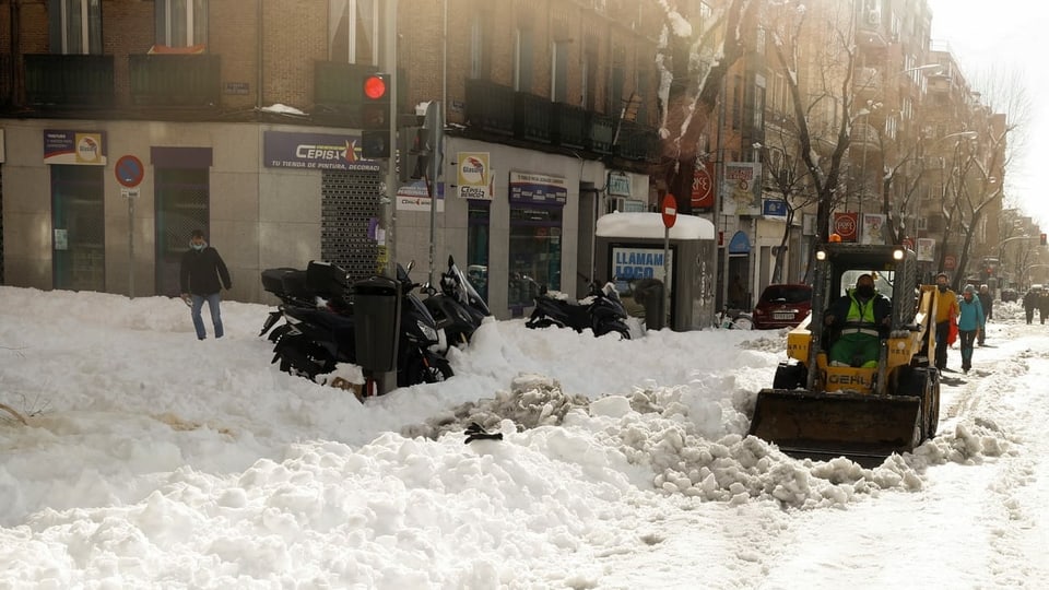 Ein Fahrzeug räumt Schnee auf einer Madrider Strasse weg.
