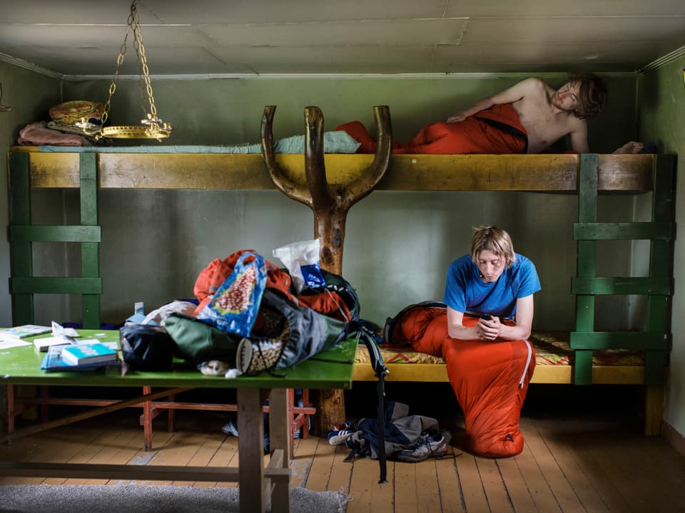 Ein Mann und eine Frau in einem Hochbett in einer schwedischen Ferienhütte.