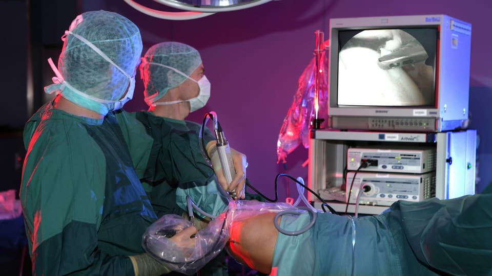 Arthroskopie: Zwei Chirurgen operieren ein Knie mittels Arthroskopie.