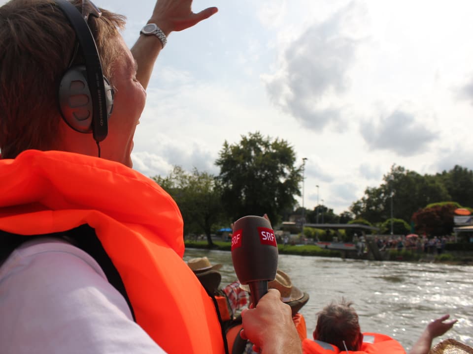 Reto Scherrer jubelt aus dem Boot den Zuschauern am Ufer zu.