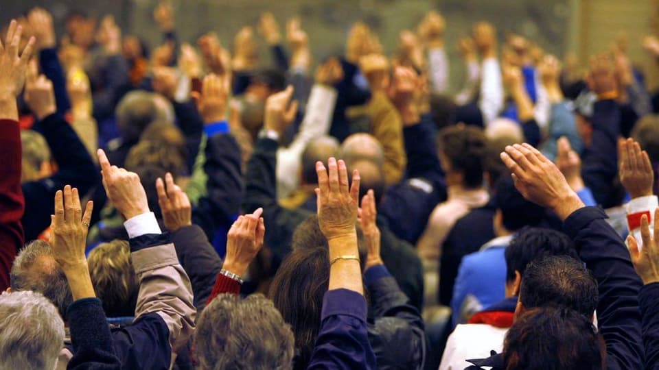 Hände in einer Abstimmung einer Gemeindeversammlung