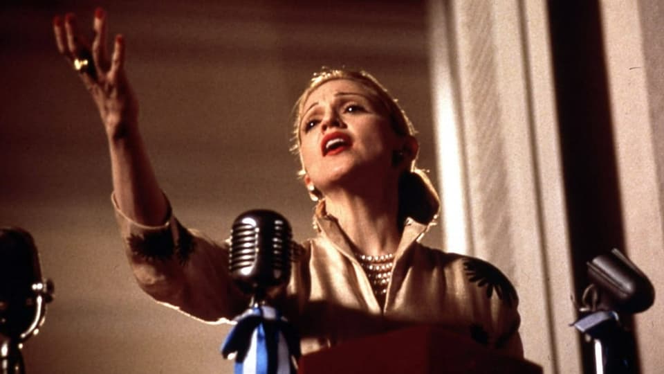Junge Frau singend auf einem Balkon mit Mikrophon.