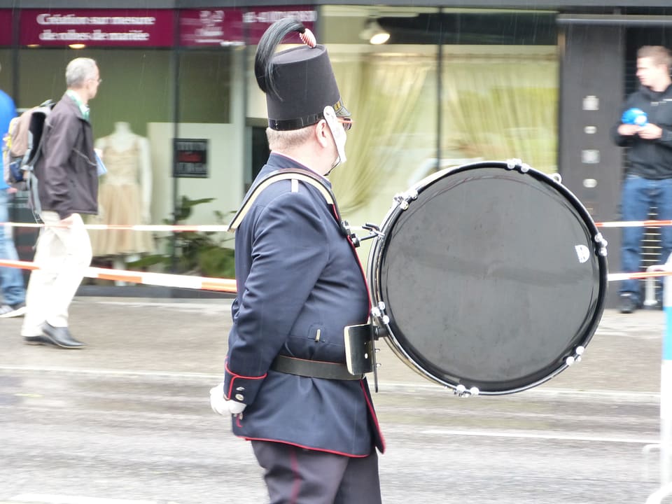 Ein uniformierter Musikant mit einer Trommel vor dem Bauch.