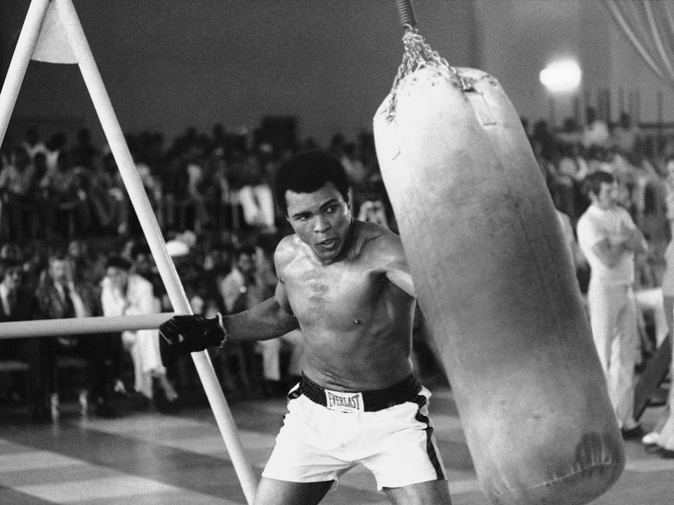 Muhammad Ali drischt auf einen Boxsack ein auf einer Aufnahme von 1974