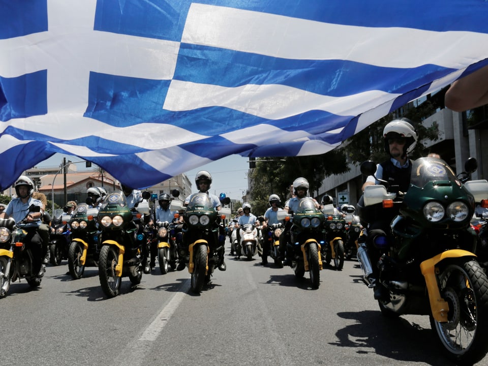 Polizisten auf Motorrädern unter einen Griechenland-Flagge