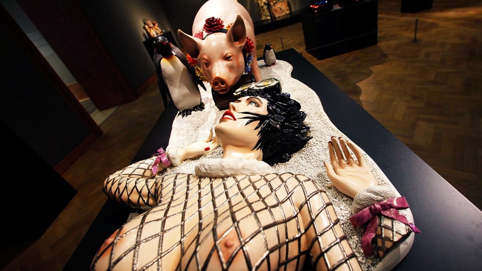 Porzellanskulptur: Frau liegt lasziv vor einem Schwein.