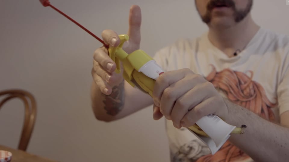 Guido spannt eine Banane in eine spezielle Halterung und hölt sie aus