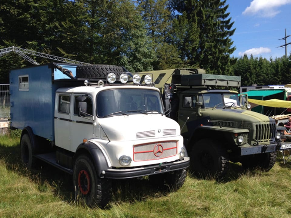 Zwei umgebaute Trucks auf einer Wiese