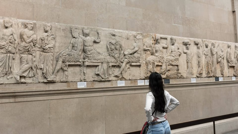 Eine Frau Blickt auf griechische Marmorskulpturen