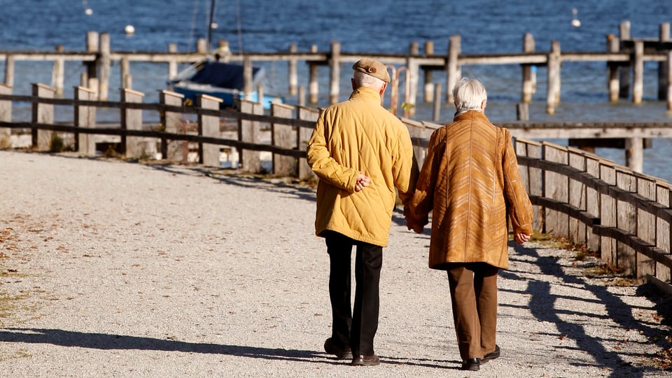 Ältere Mann und ältere Frau spazieren am See