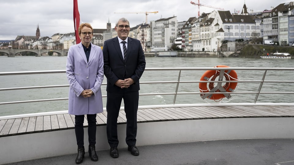 Eric Nussbaumer und Eva Herzog stehen nebeneinander auf einem Rheinschiff, hinter ihnen sieht man die Stadt Basel.