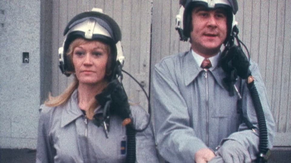 Rosemarie Pfluger und Kurt Felix in «Grüezi mitenand» mit Helm und Rennanzug.